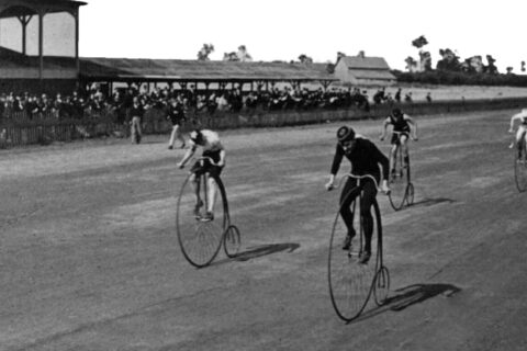 Black and white historical photos of cyclists racing on boneshaker bikes