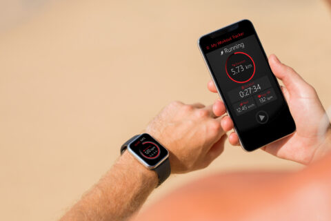 Athlete comparing fitness data on their watch with their smartphone