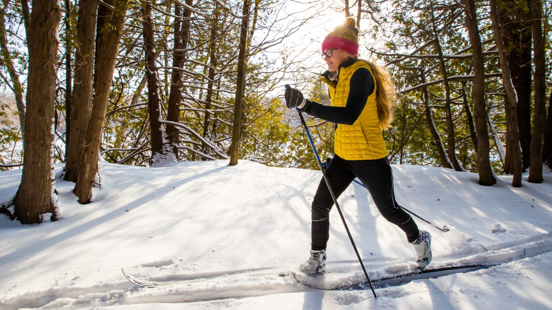 Woman cross-country skiing through the woods