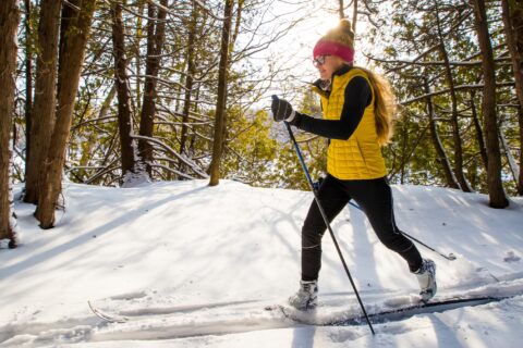 Woman cross-country skiing through the woods
