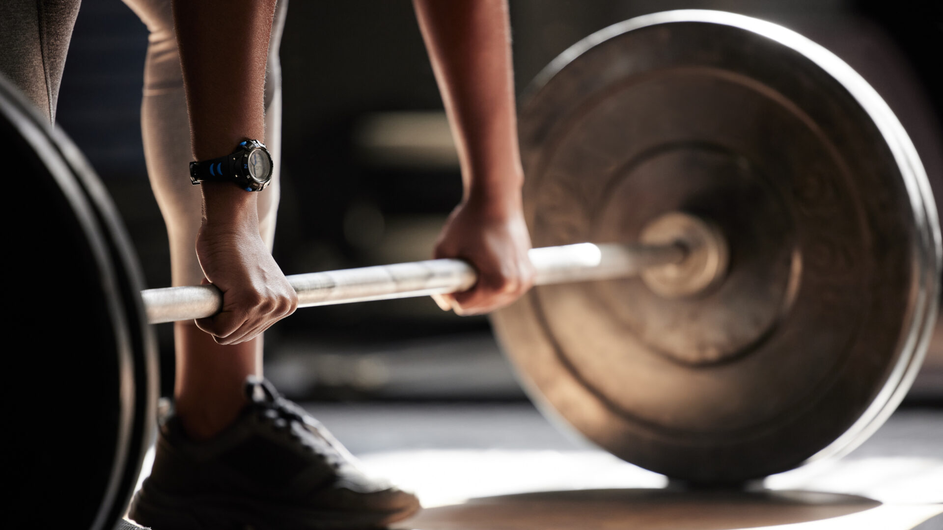 Closeup of a man about to deadlift a barbell