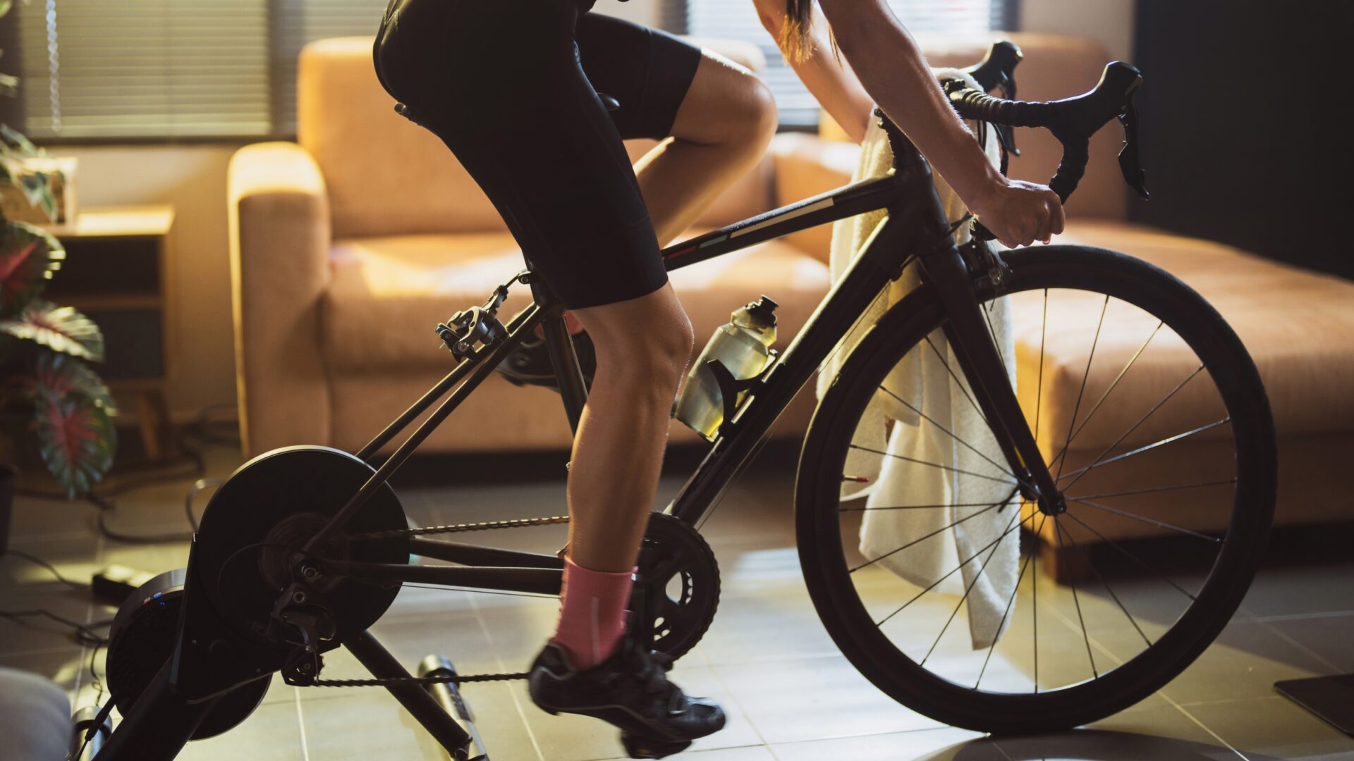 Cropped image of a woman riding on an indoor trainer