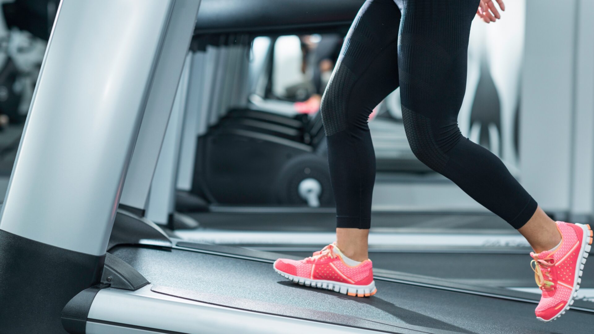 Lower half of a woman walking on an inclined treadmill