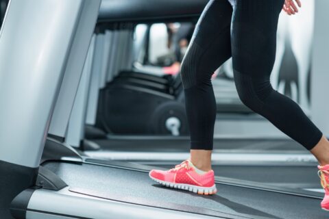 Lower half of a woman walking on an inclined treadmill