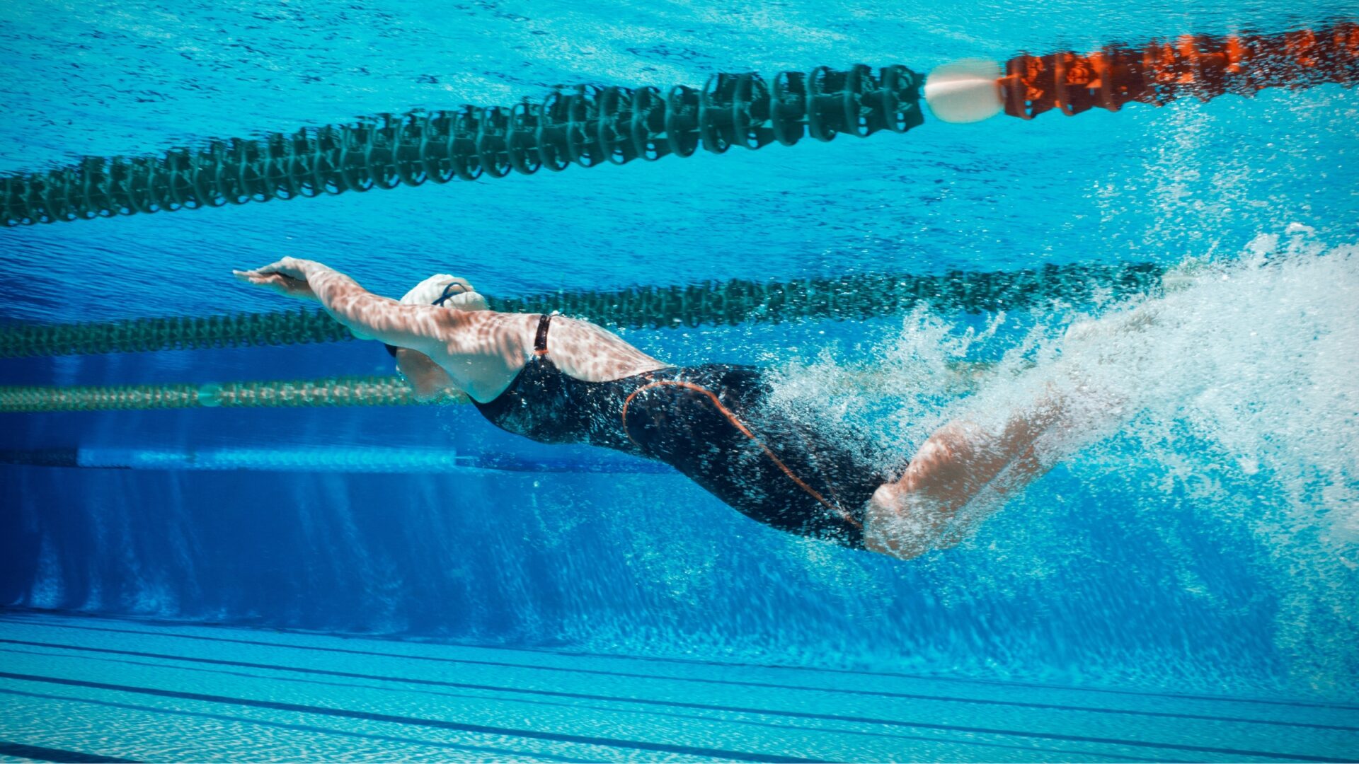 Underwater view of a swimmer dolphin kicking in a pool