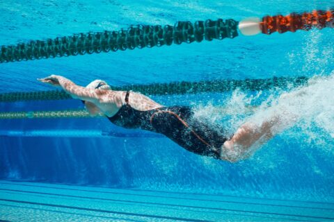 Underwater view of a swimmer dolphin kicking in a pool