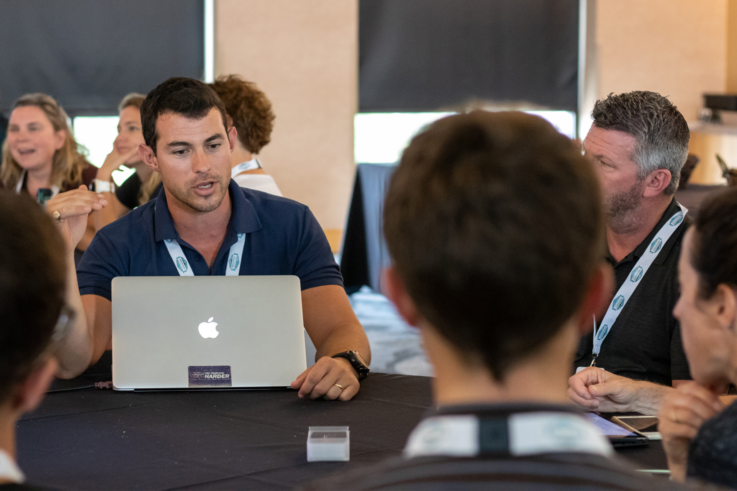 Endurance coach Philip Hatzis speaks with other coaches at an endurance sports coaching conference.