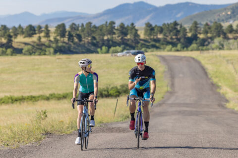 Fast Talk Labs Head Coach Ryan Kohler coaches a female cyclist while on a bike ride near Boulder, Colorado.