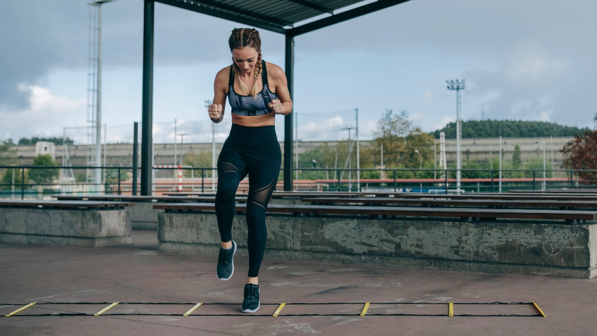 Woman doing single-leg lateral hops over an agility ladder