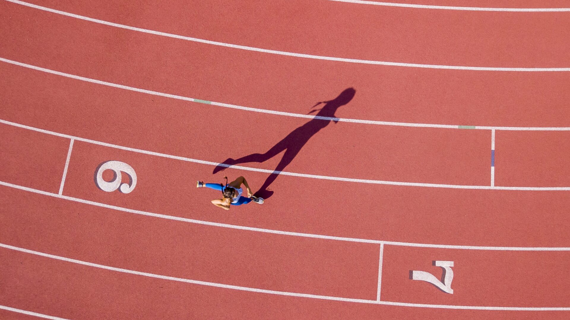 Above shot of a woman rounding a corner on a running track