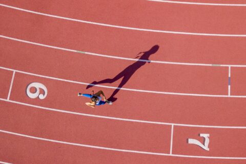 Above shot of a woman rounding a corner on a running track