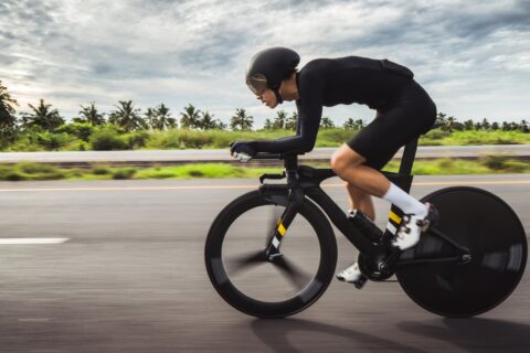 Male athlete time trialing on a bike